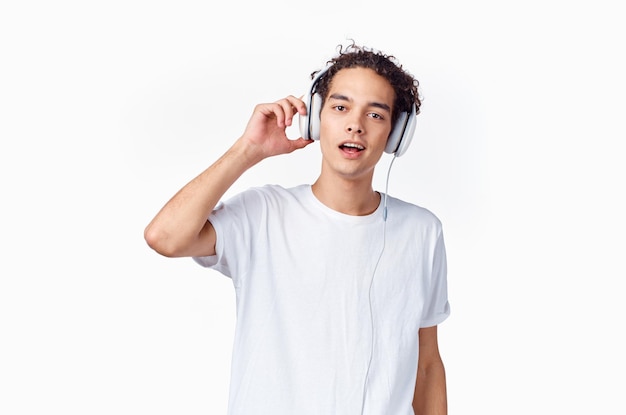 Homem com cabelo encaracolado ouvindo música com fones de ouvido camiseta nova tecnologia de moda adolescente