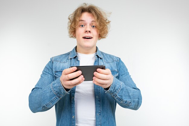 Homem com cabelo loiro ondulado venceu um jogo de telefone em um smartphone