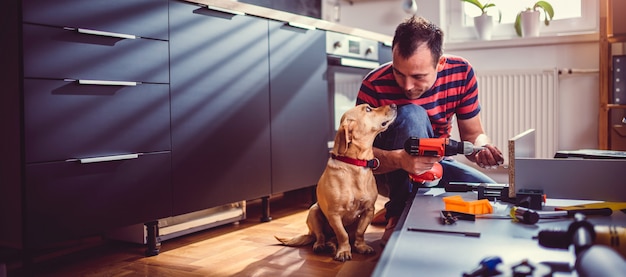 Homem com cachorro, construção de armários de cozinha