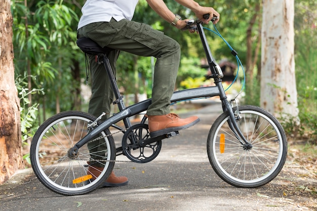 Homem, com, calças cargo, andar uma bicicleta, em, a, jardim