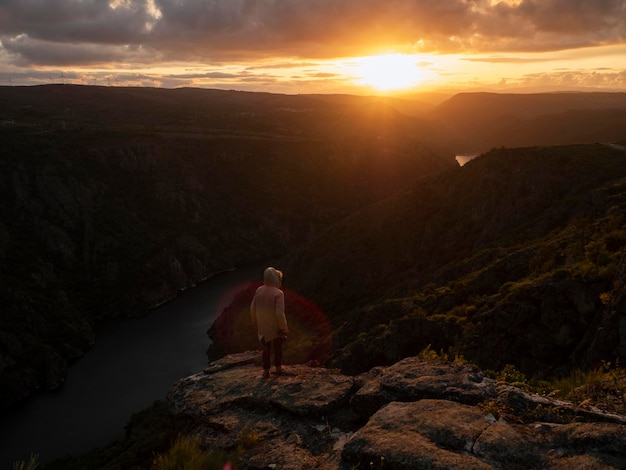 homem com câmera assistindo o pôr do sol