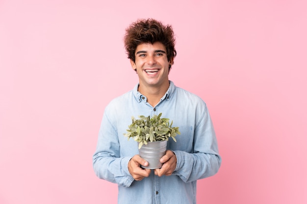 Homem com camisa azul posando com planta