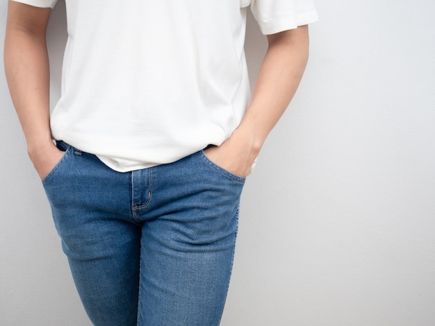 Homem com camisa branca e mão no bolso do jeans.