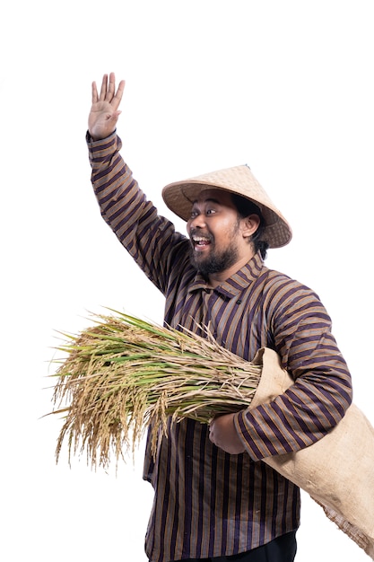 Foto homem com camisa de lurik tradicional javanesa segurando grãos de arroz