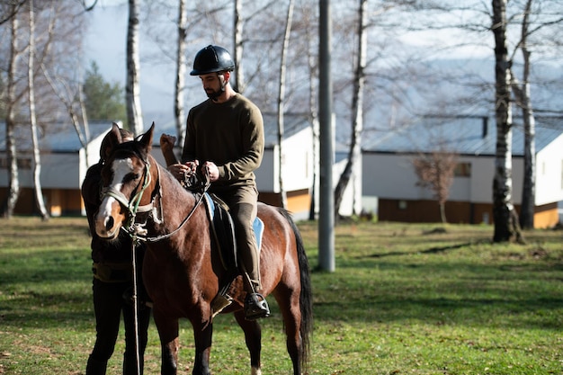 Homem com capacete andando a cavalo na floresta