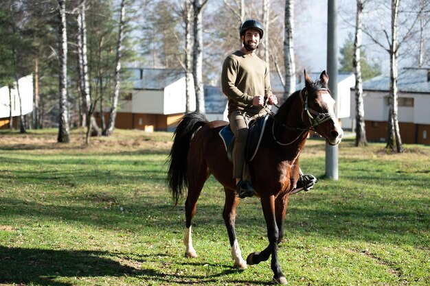 Homem com capacete andando a cavalo na floresta