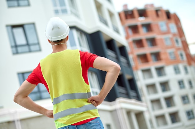 Homem com capacete de segurança diante de uma estrutura construída