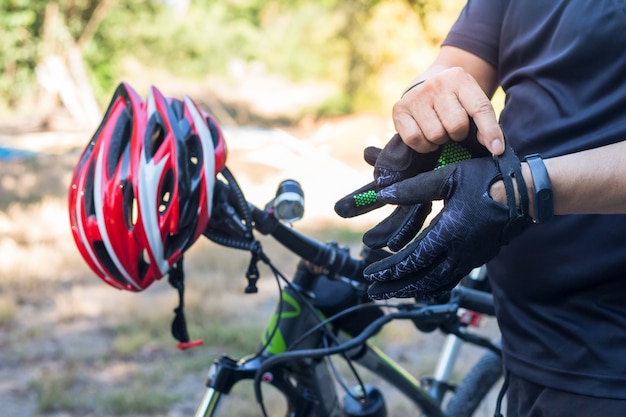 Homem, com, capacete, luva, para, segurança, ande uma bicicleta, em, estrada rural, ao longo, um, floresta