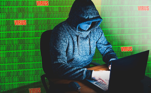 Homem com capuz está hackeando dados pessoais sobre fundo verde. Segurança da informação. Conceito de vírus virtual. Proteção da informação. Senha inválida.