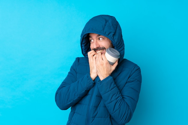 Homem com casaco de inverno sobre parede isolada