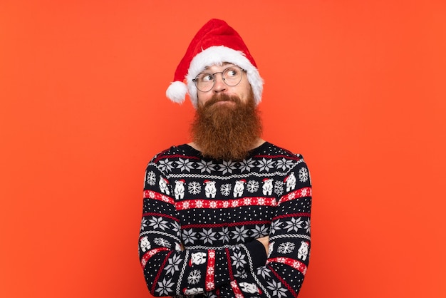 Homem com chapéu de natal sobre fundo vermelho isolado