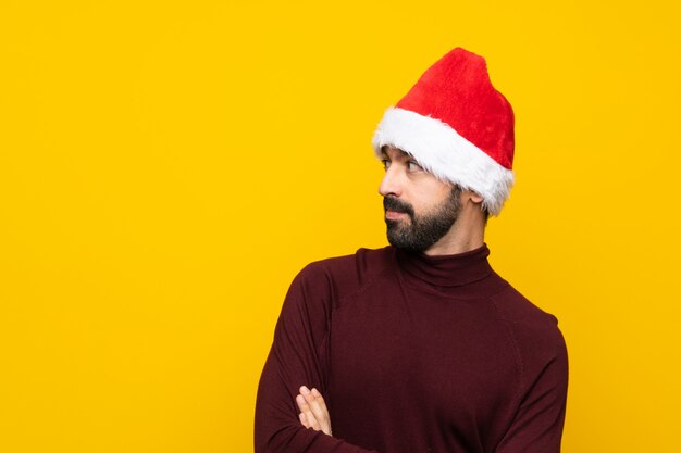 Homem com chapéu de Natal sobre retrato de fundo amarelo isolado