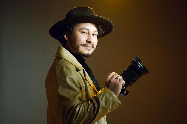 homem com chapéu segurando uma câmera fotográfica