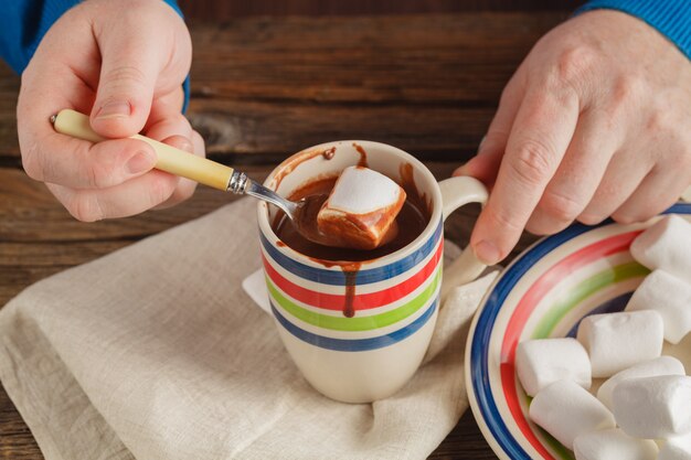 Homem com chocolate quente caneca com marshmallows, bebida de Natal de inverno