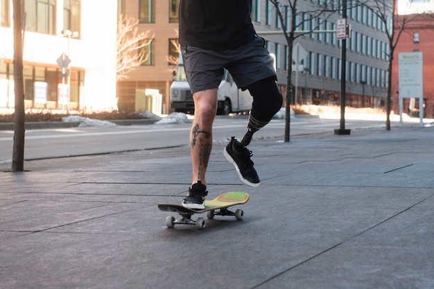 Foto homem com deficiência de perna andando de skate na cidade