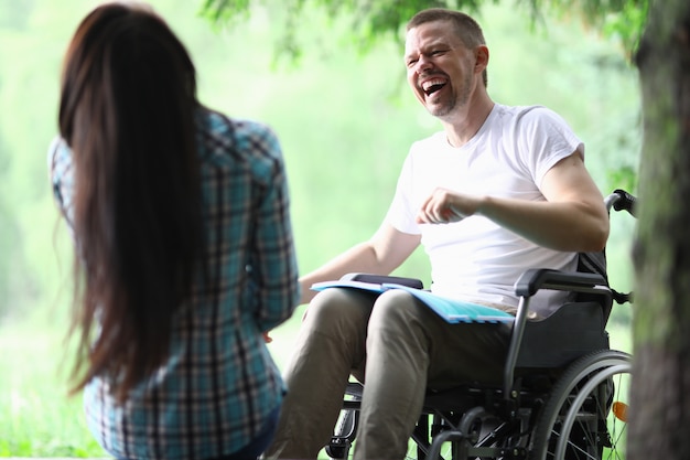 Homem com deficiência masculino com namorada sorrindo no retrato de caminhada do parque