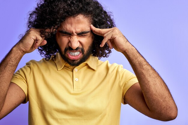 Homem com dor de cabeça isolada, segurar a cabeça com a mão, dor nas têmporas, ficar com os olhos fechados, isolado no espaço roxo