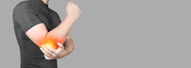 Homem com dor de cotovelo em fundo cinza homem que sofre de reumatismo articular crônico acidente articular com espaço de cópia de faixa de fisioterapia