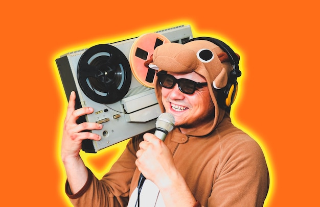 Homem com fantasia de cosplay de uma vaca com gravador de bobina. cara na roupa de dormir do pijama animal. foto engraçada com ideias de festa. música retro discoteca.