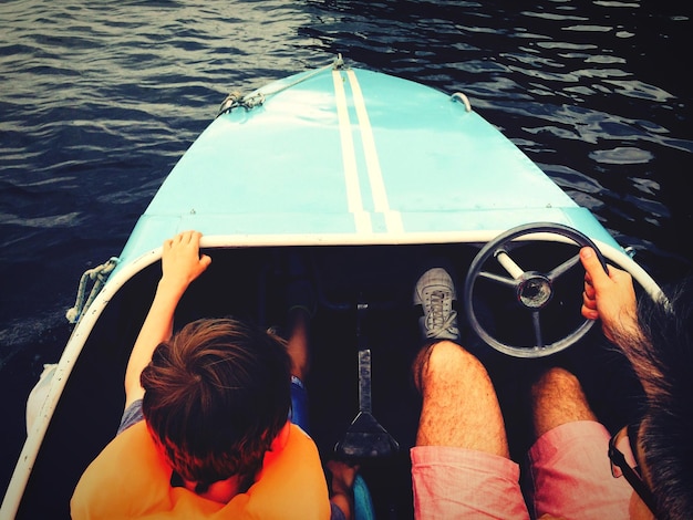 Foto homem com filho sentado em um barco a motor