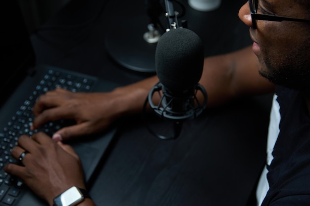 Homem com fones de ouvido grava ou transmite um podcast usando um microfone no estúdio