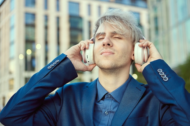 Homem com fones de ouvido sem fio perto do centro comercial