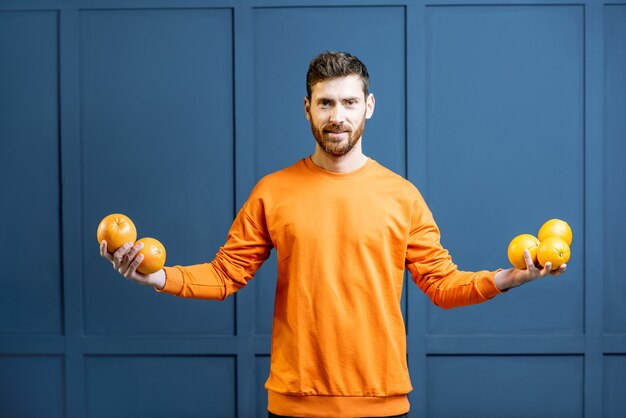 Homem com frutas no fundo azul