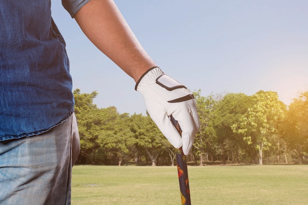 Homem com golfe no gramado.