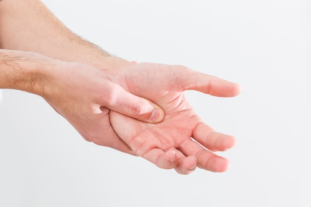 Homem com gota dolorosa e inflamada na mão ao redor da área do polegar.