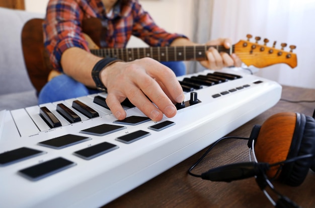 Foto homem com guitarra e sintetizador closeup