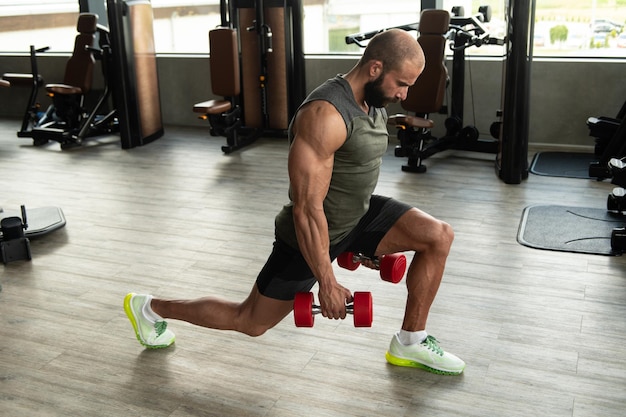 Homem com halteres exercitando quadríceps e glúteos