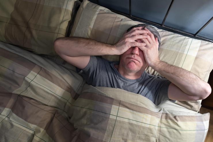 Homem com insônia deitado na cama e resfriando de exaustão