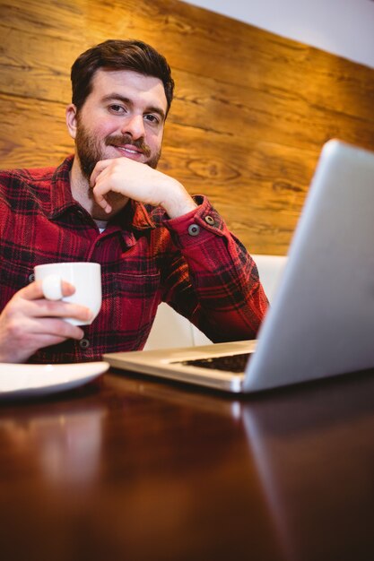Homem com laptop e café no restaurante