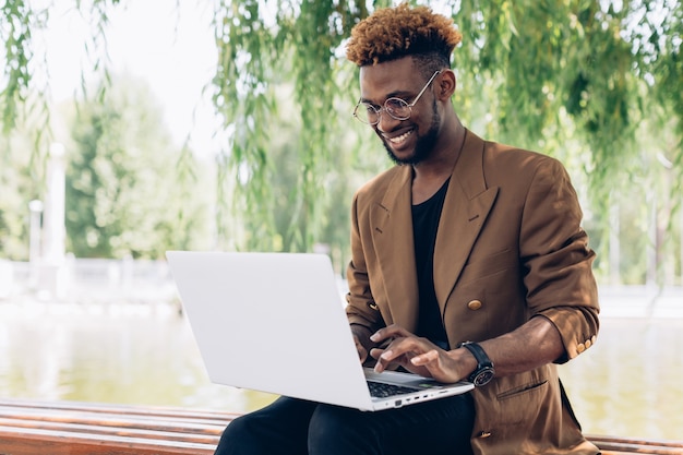 Foto homem com laptop no banco