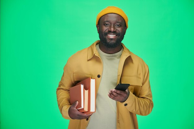 Homem com livros usando seu smartphone