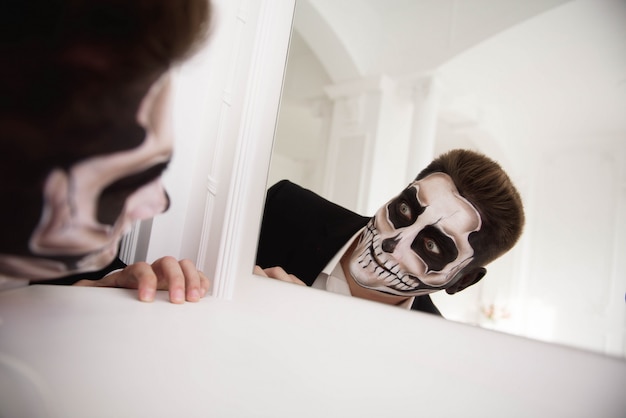 Homem com make-up Halloween. Desenhando um vampiro, esqueleto