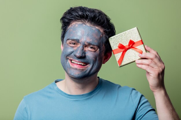 Homem com máscara limpa e caixa de presente
