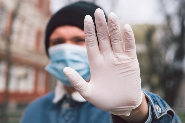 homem com máscara protetora e luvas ao ar livre