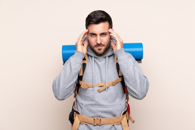 Homem com mochila alpinista sobre parede isolada