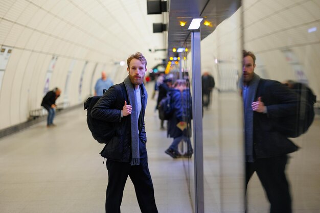 Homem com mochila entra em um trem do metrô em uma estação