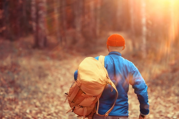 homem com mochila vista de trás, caminhadas na floresta, paisagem de outono, costas de turista com mochila