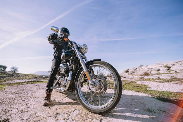 Foto homem com moto em rocha