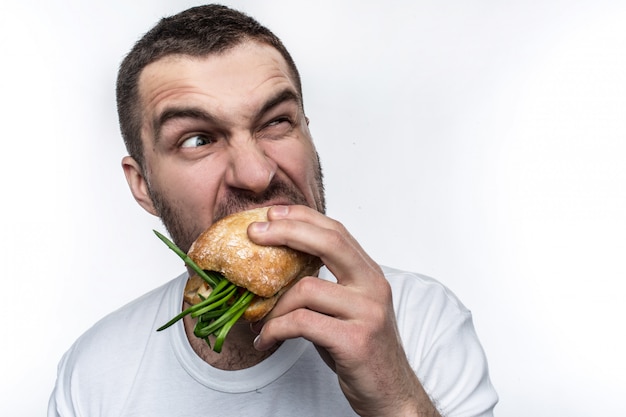 Homem com muita fome está comendo um hambúrguer