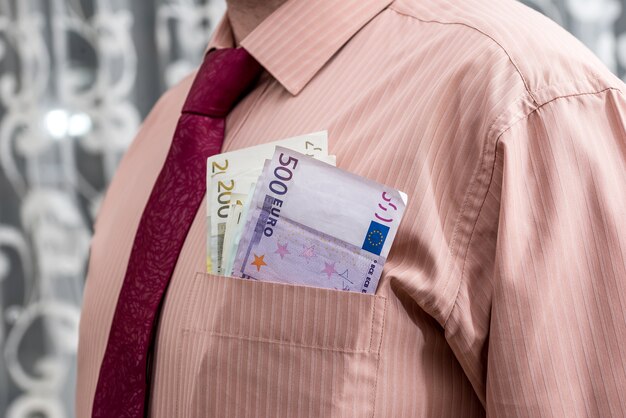 Homem com notas de euro no bolso da camisa