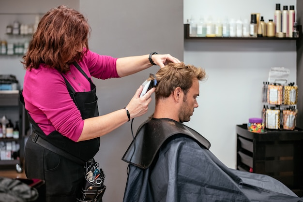 Homem com o cabelo cortado em uma barbearia