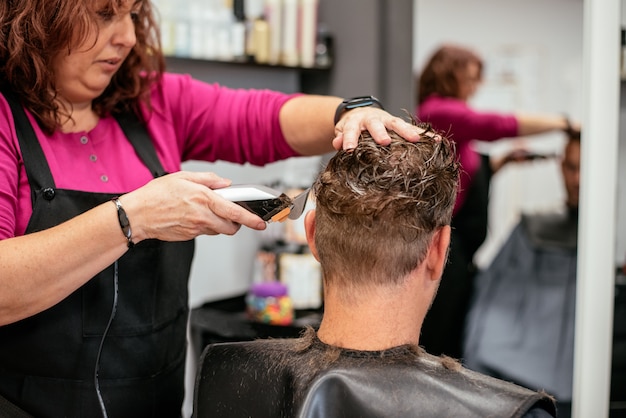 Homem com o cabelo cortado em uma barbearia