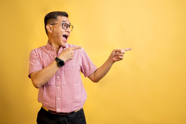 Homem com óculos e camisa apontando para algo