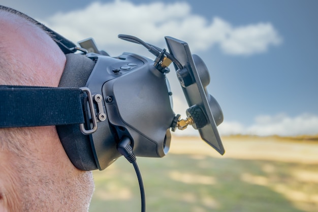 Homem com óculos FPV HD, pilotando drone de corrida