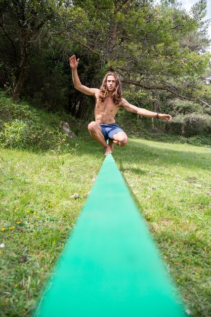 Foto homem com os braços levantados na floresta