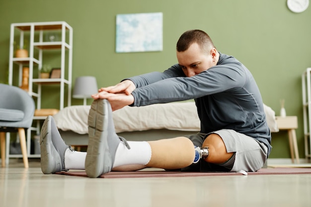 Homem com perna protética fazendo exercícios de alongamento